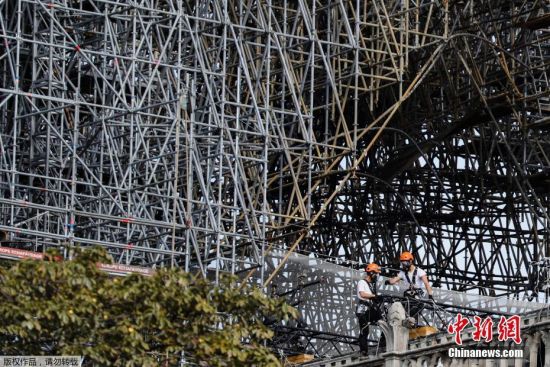 当地时间8月19日，法国巴黎圣母院修复工程第一天，工人戴着面罩在大教堂受损区域进行调查。由于巴黎圣母院部分建材含铅，在火灾中释出大量含铅灰尘，为保障工人健康，重建工作自7月25日暂时停止。